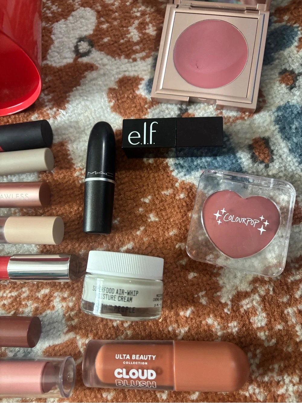 Glossier red mini bucket with mixed pink and mauve lip products